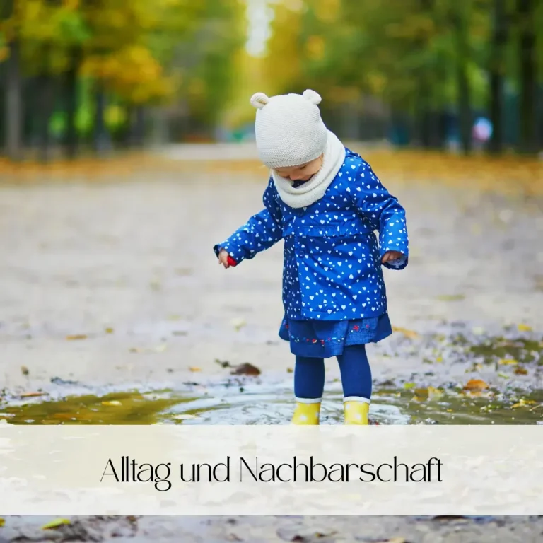 Eine Frau mit buntem Regenschirm geht mit einem kleinen Jungen in einem herbstlichen Park.