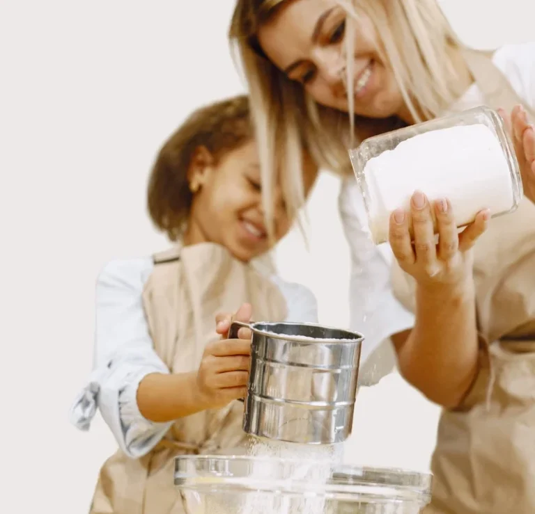 Eine Mutter und ihre Tochter messen gemeinsam Zutaten in der Küche.