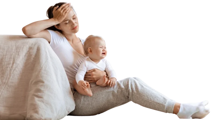 Für wen ist der mini selfcare guide gemacht Mutter sitzt erschöpft auf dem Sofa und hält ein lächelndes Baby im Arm.