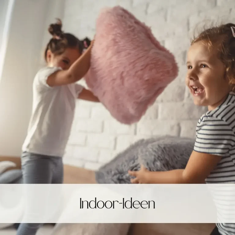 Zwei Kinder spielen mit Kissen in einem hellen, gemütlichen Raum.
