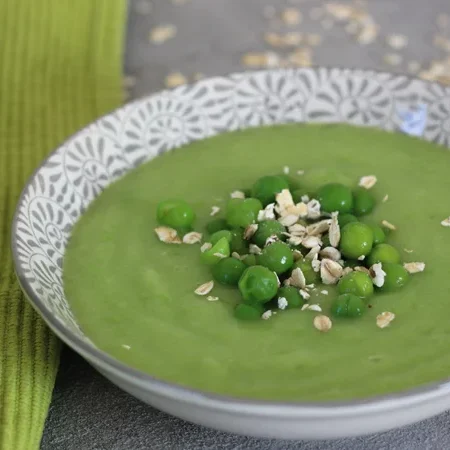 Grüne Erbsensuppe mit Erbsen und Haferflocken in einer dekorativen Schüssel.
