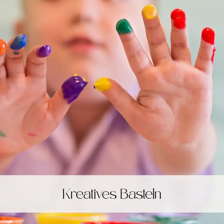 Bunte Hände eines Kindes, das mit Farben kreativ arbeitet.